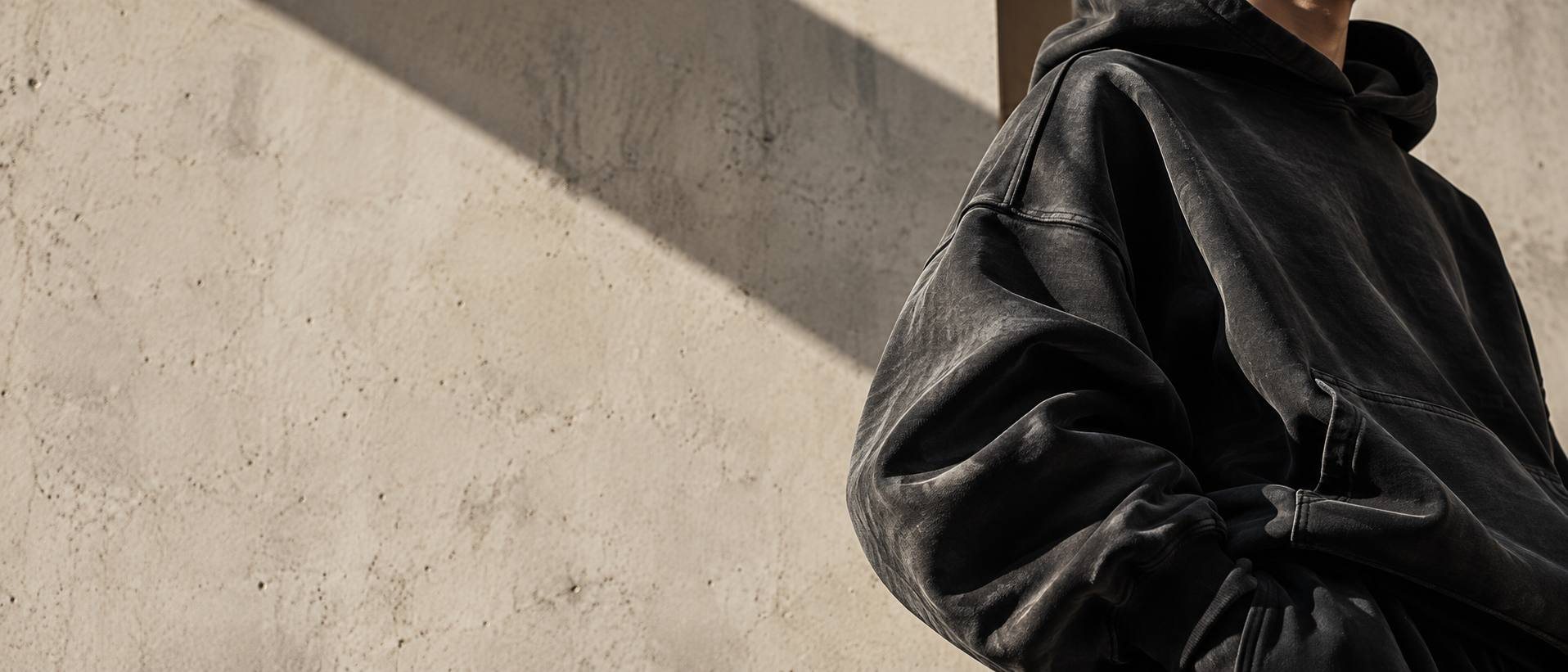 Rukáv Still Hoodie u betonové zdi